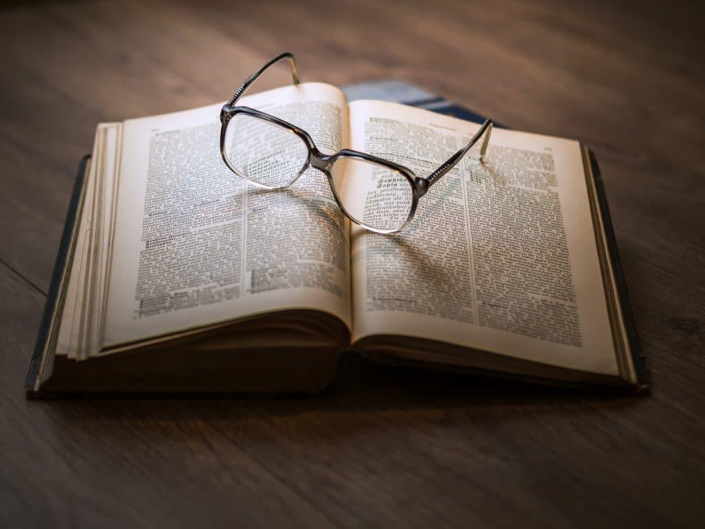 book with glasses on desk